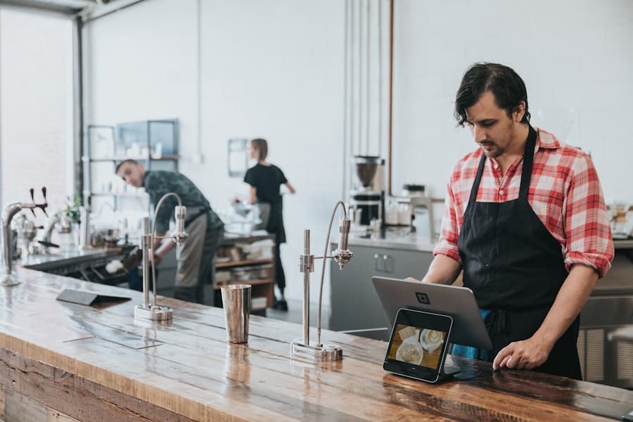 Shift lead checking the daily log on a tablet at the counter